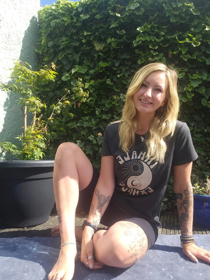 Katie is sat in a relaxed welcoming pose